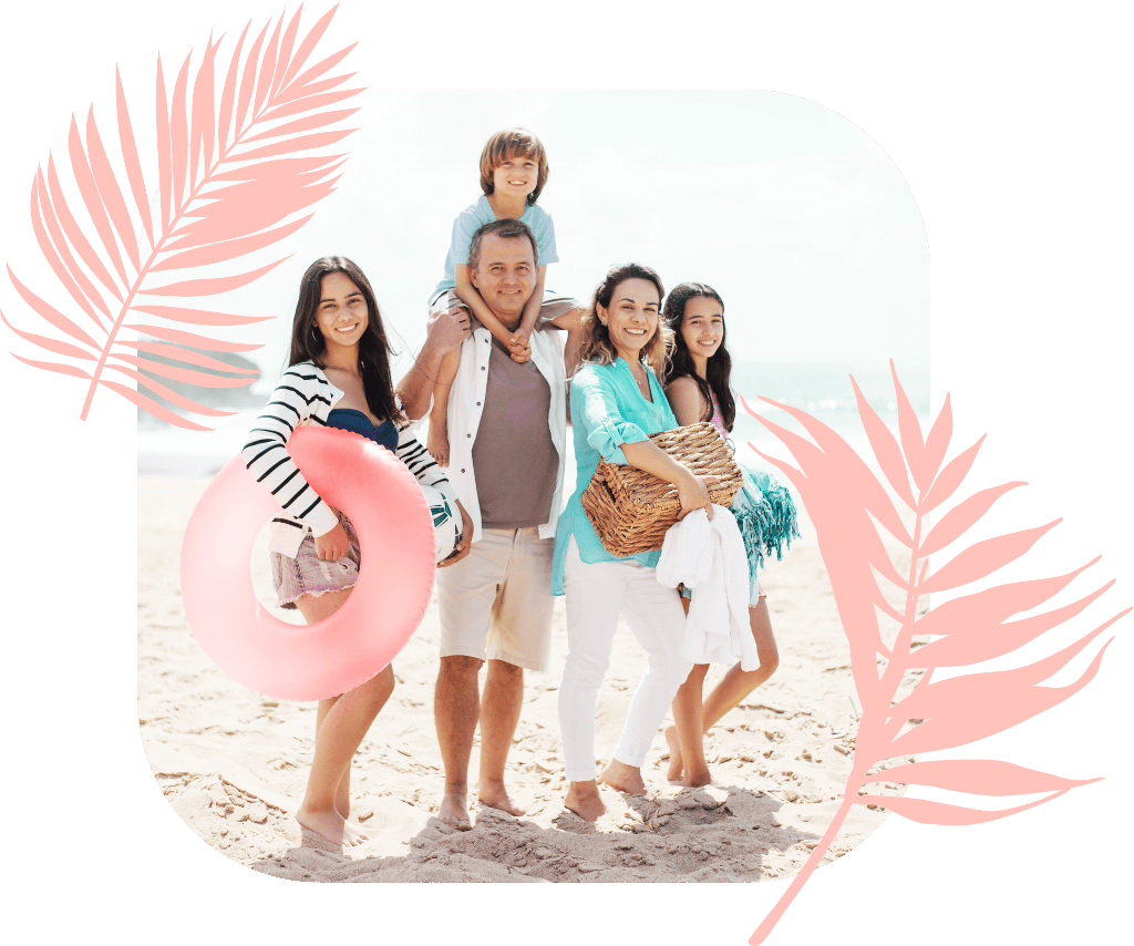 A family on holiday on the beach on a sunny day, Mum holding a picnic basket and one child carrying a rubber ring