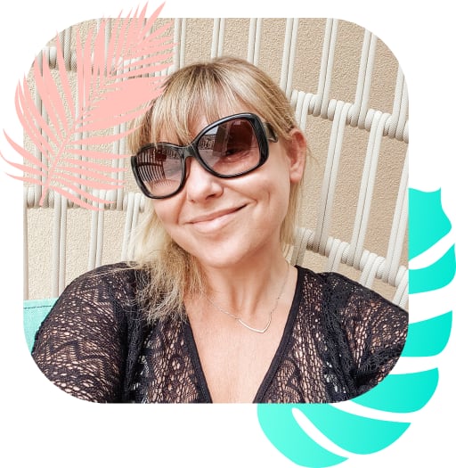 Janine from The JLT Group smiling at the camera with her sunglasses on and sat in a wicker chair