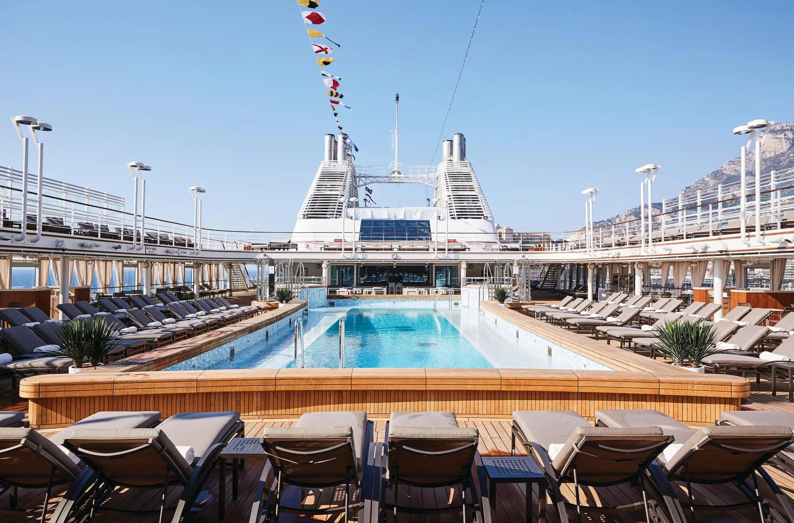 A Silversea ship's outdoor pool deck with teak loungers